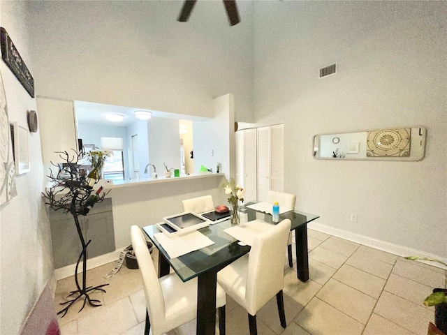 dining room with a high ceiling and light tile patterned flooring