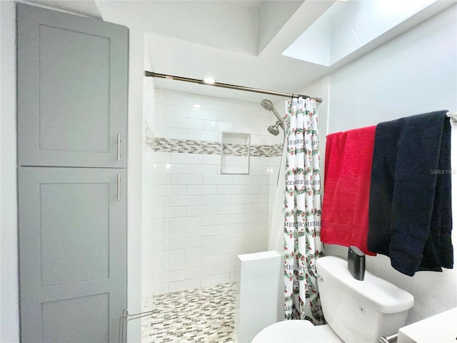 bathroom with a skylight, toilet, and curtained shower