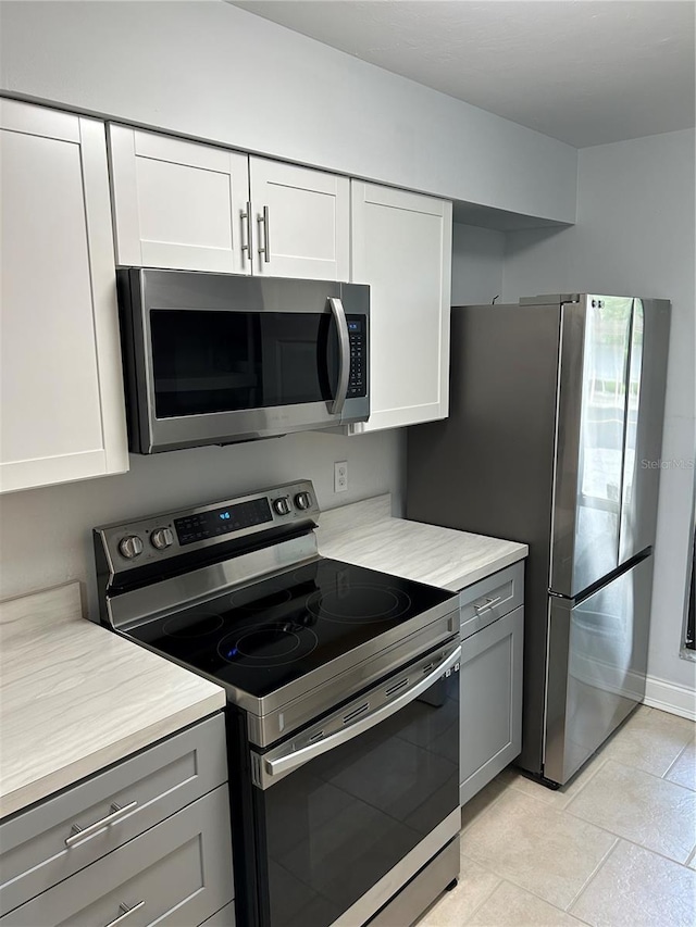 kitchen with white cabinetry, gray cabinets, and appliances with stainless steel finishes