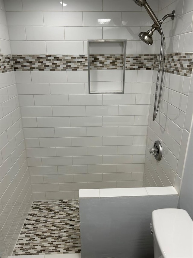 bathroom featuring toilet and tiled shower