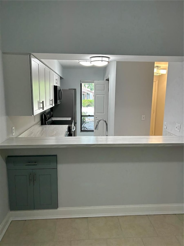 kitchen featuring light tile patterned flooring, sink, kitchen peninsula, green cabinets, and black range with electric stovetop