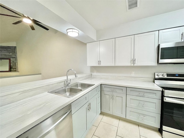 2820 NW 39th Ter, Gainesville, FL 32606 - kitchen with stainless steel appliances, a sink, light countertops, a ceiling fan, and light tile patterned floors