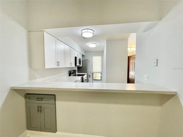 2820 NW 39th Ter, Gainesville, FL 32606 - kitchen featuring stainless steel appliances, light countertops, white cabinets, and a peninsula