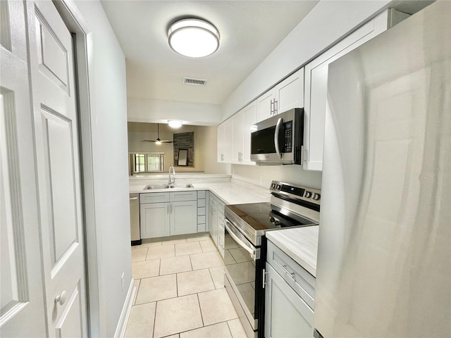 2820 NW 39th Ter, Gainesville, FL 32606 - kitchen featuring appliances with stainless steel finishes, a sink, light tile patterned flooring, light countertops, and a ceiling fan