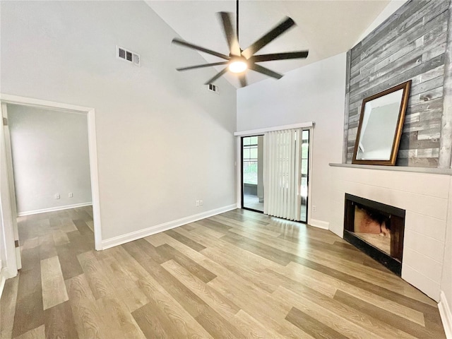 2820 NW 39th Ter, Gainesville, FL 32606 - unfurnished living room featuring high vaulted ceiling, a ceiling fan, wood finished floors, a tile fireplace, and baseboards