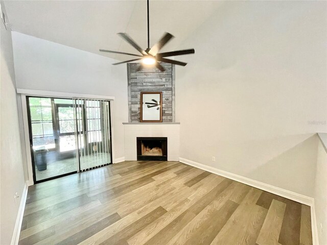 2820 NW 39th Ter, Gainesville, FL 32606 - unfurnished living room featuring high vaulted ceiling, baseboards, ceiling fan, wood finished floors, and a fireplace