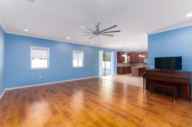 unfurnished living room with ornamental molding, ceiling fan, and light wood-type flooring