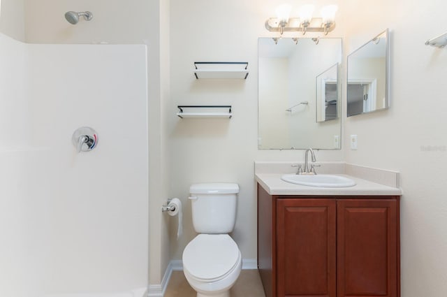 bathroom featuring vanity, toilet, and walk in shower