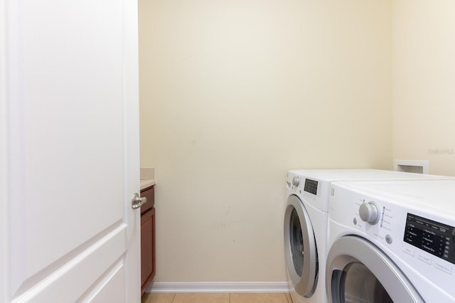 laundry area featuring cabinets, washing machine and clothes dryer, and light tile patterned flooring