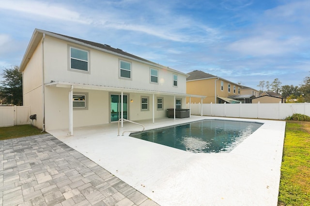 back of property featuring a fenced in pool and a patio