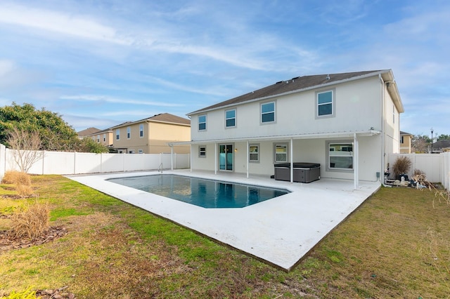 rear view of house featuring a fenced in pool, a patio area, and a lawn