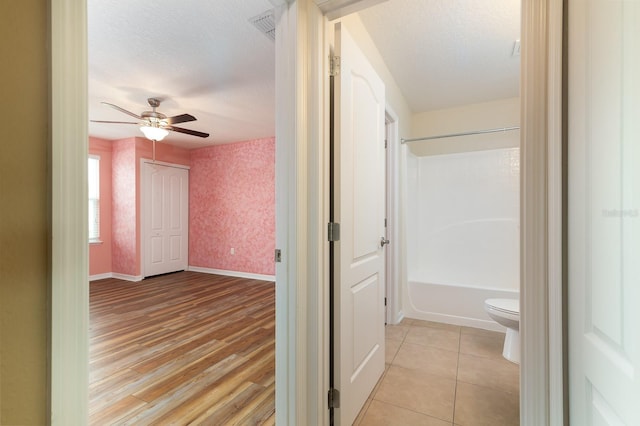 24448 SW 8th Pl, Newberry, FL 32669 - corridor with a textured ceiling, wallpapered walls, baseboards, and light wood-type flooring