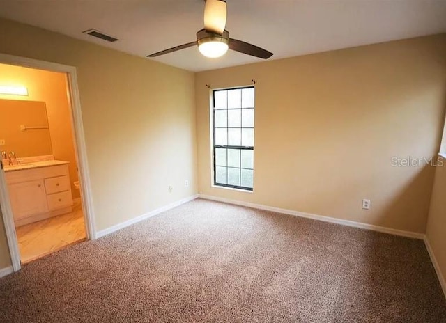 carpeted empty room featuring ceiling fan and sink