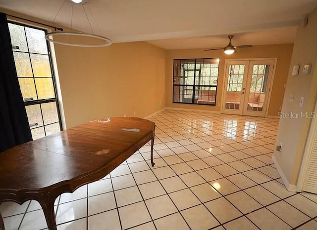 unfurnished dining area with french doors, ceiling fan, and light tile patterned flooring