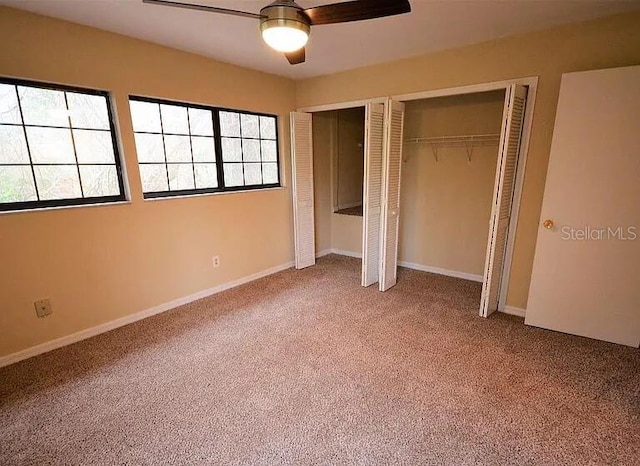 unfurnished bedroom with ceiling fan, carpet floors, and two closets