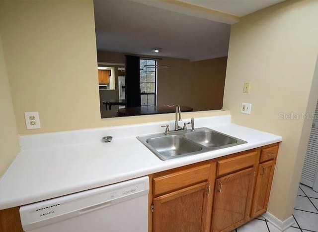 kitchen featuring dishwasher, sink, light tile patterned floors, and kitchen peninsula