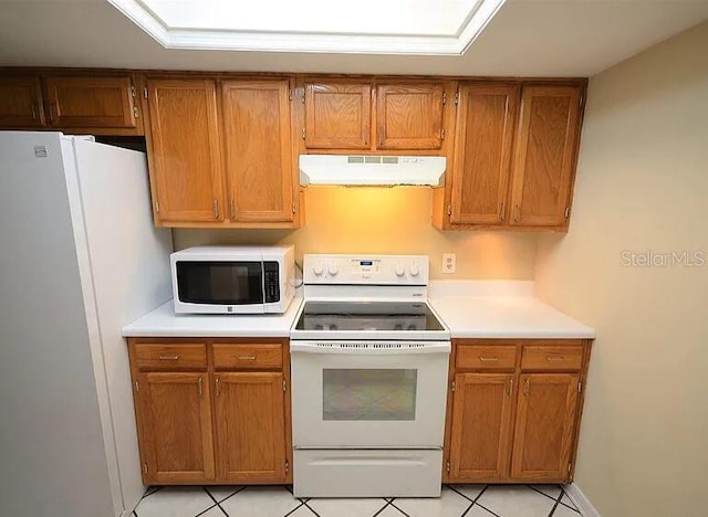 kitchen with white appliances and light tile patterned floors