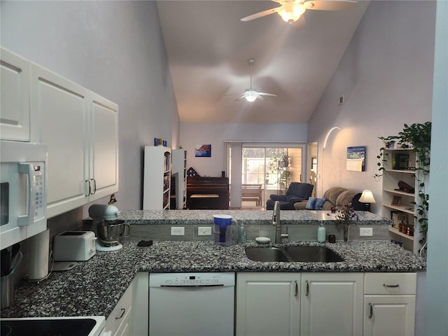 kitchen featuring sink, white cabinetry, dark stone countertops, ceiling fan, and white appliances