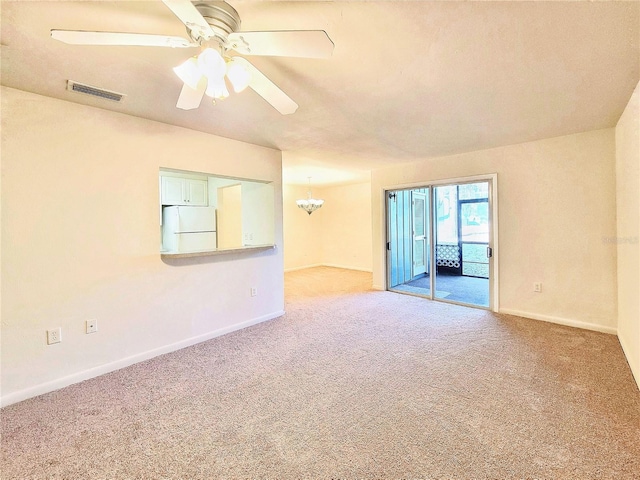 carpeted empty room with ceiling fan with notable chandelier