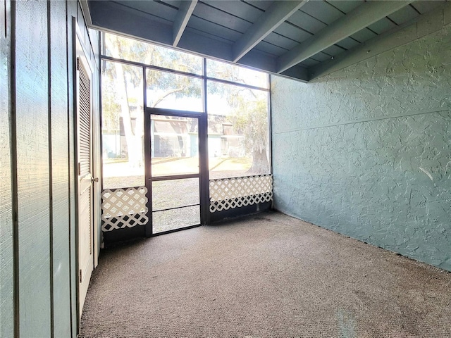 unfurnished sunroom featuring beamed ceiling