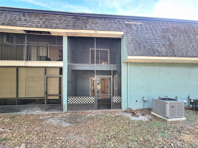 rear view of house featuring cooling unit and a sunroom