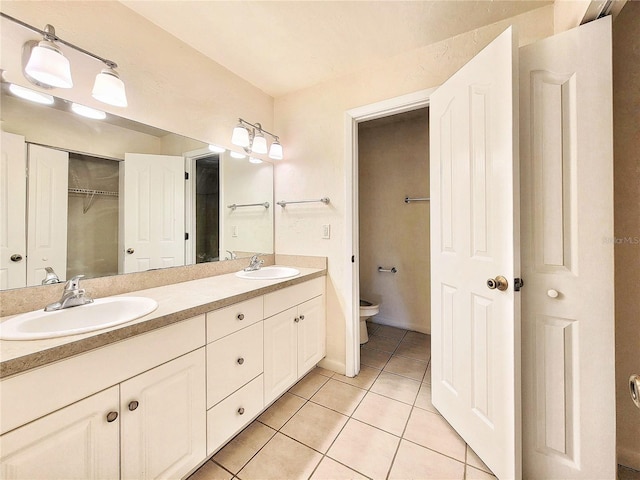 bathroom featuring vanity, tile patterned floors, and toilet