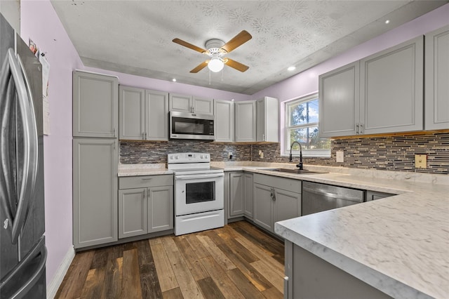 kitchen featuring dark hardwood / wood-style flooring, sink, gray cabinets, and stainless steel appliances