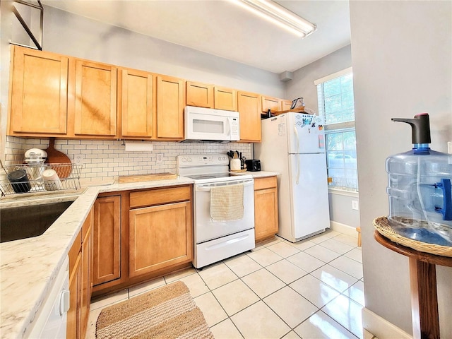 kitchen with sink, white appliances, tasteful backsplash, light tile patterned flooring, and light brown cabinetry