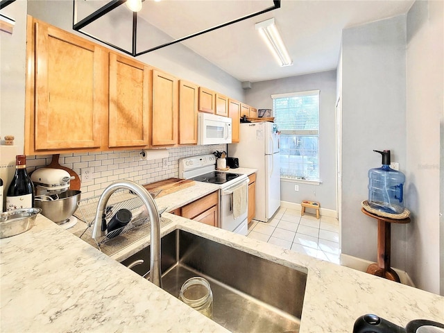 kitchen featuring sink, white appliances, light tile patterned floors, light brown cabinetry, and decorative backsplash