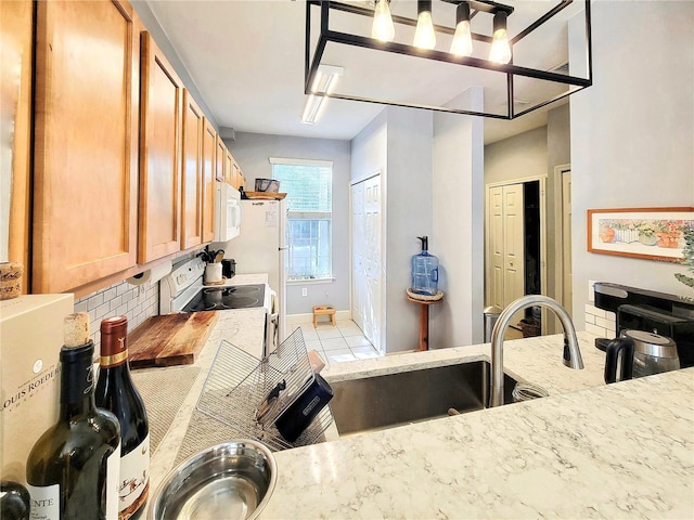 kitchen with tasteful backsplash, light tile patterned flooring, sink, and white appliances