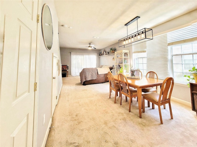 dining room featuring light carpet and ceiling fan