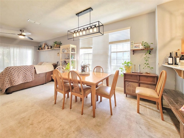 dining area featuring light carpet and ceiling fan