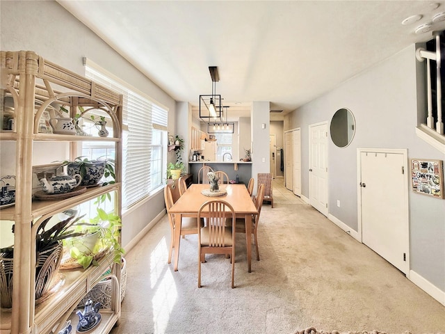 carpeted dining area featuring an inviting chandelier