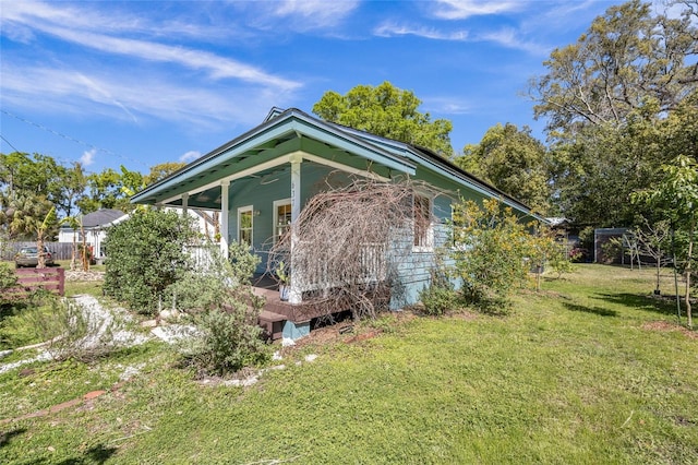 view of side of home featuring a porch and a lawn