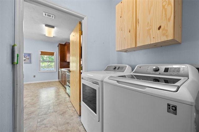 laundry area with washer and dryer, visible vents, cabinet space, and baseboards