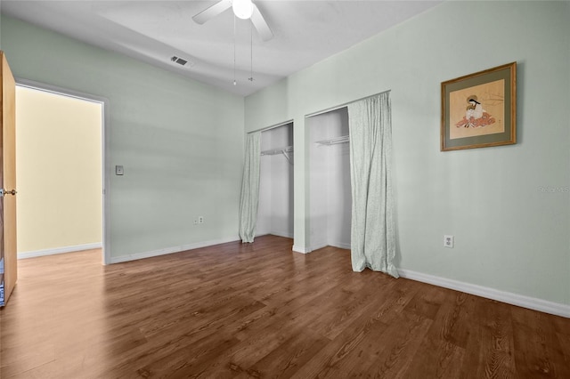 unfurnished bedroom with visible vents, wood finished floors, baseboards, and ceiling fan