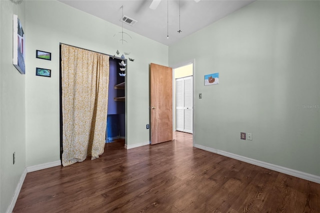 unfurnished bedroom with a ceiling fan, wood finished floors, visible vents, and baseboards