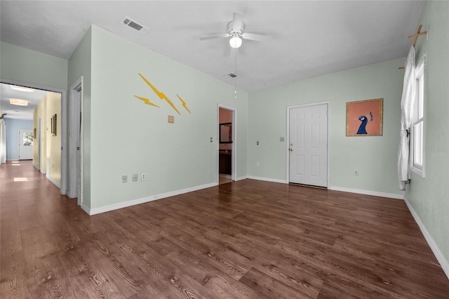 unfurnished living room featuring visible vents, baseboards, dark wood-style floors, and ceiling fan