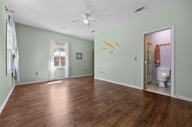 unfurnished bedroom featuring visible vents, ensuite bathroom, baseboards, and wood finished floors