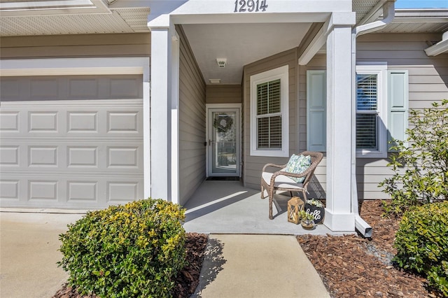 doorway to property with a porch and a garage