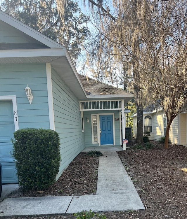 view of exterior entry featuring a garage and covered porch