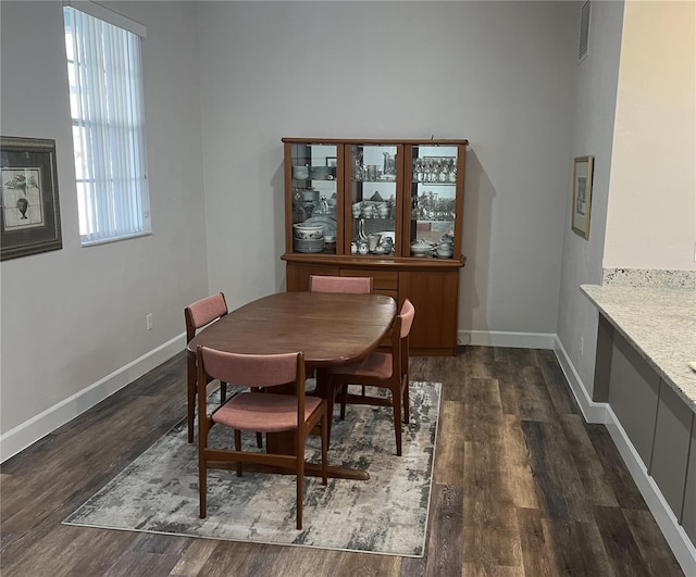 dining space with dark hardwood / wood-style flooring