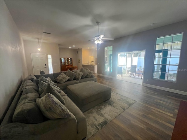 living room featuring dark wood-type flooring and ceiling fan