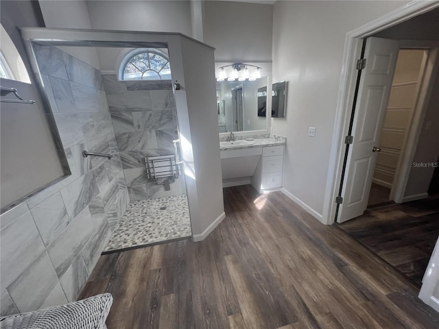 bathroom featuring hardwood / wood-style floors, vanity, and a tile shower