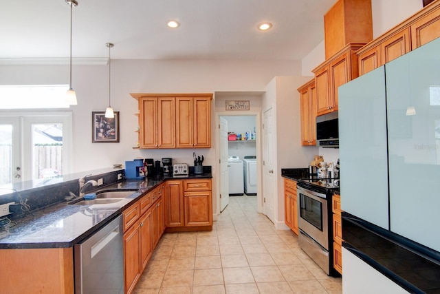 kitchen with sink, light tile patterned floors, hanging light fixtures, stainless steel appliances, and washer and dryer