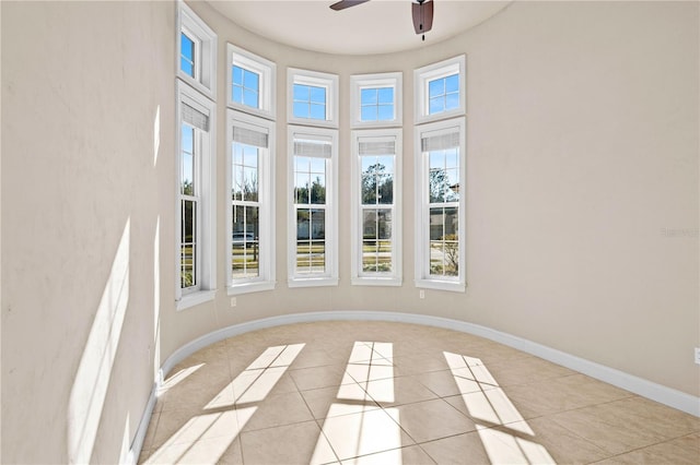 unfurnished sunroom featuring ceiling fan