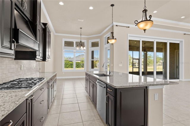 kitchen featuring sink, crown molding, hanging light fixtures, stainless steel appliances, and a kitchen island with sink