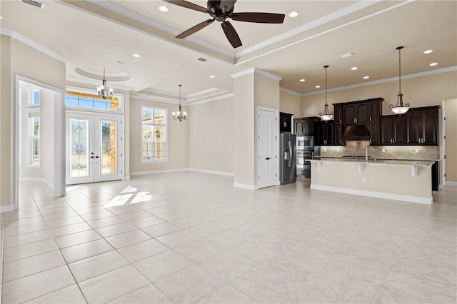 kitchen with an island with sink, appliances with stainless steel finishes, decorative light fixtures, and extractor fan