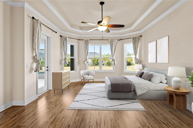 bedroom featuring dark wood-type flooring, crown molding, a raised ceiling, ceiling fan, and access to exterior