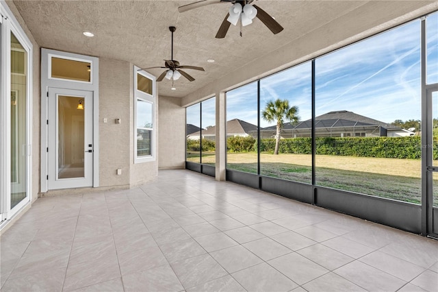 unfurnished sunroom with ceiling fan